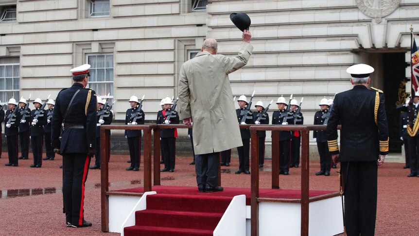 Prince Phillip doffs his hat as marines give him three cheers outside Buckingham Palace.