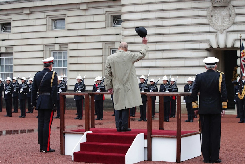 Prince Phillip doffs his hat as marines give him three cheers outside Buckingham Palace.