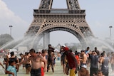 You look at the base of the Eiffel Tower in Paris from within nearby fountains within people in them on a clear day.