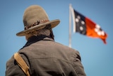 A man looks at a flag