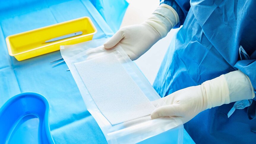 Biodegradable plastic medical scaffold NovoSorb BTM being removed from packaging by a medical professional.