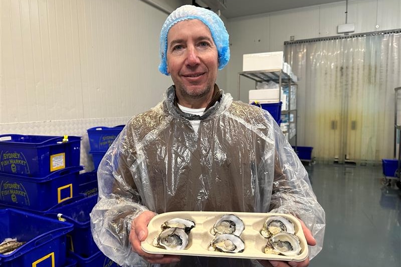 Image of a man holding a tray of oysters.
