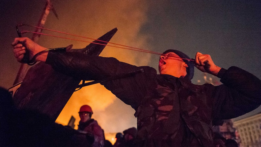 An anti-government protester fires a slingshot during clashes with riot police in Ukraine's capital Kiev.