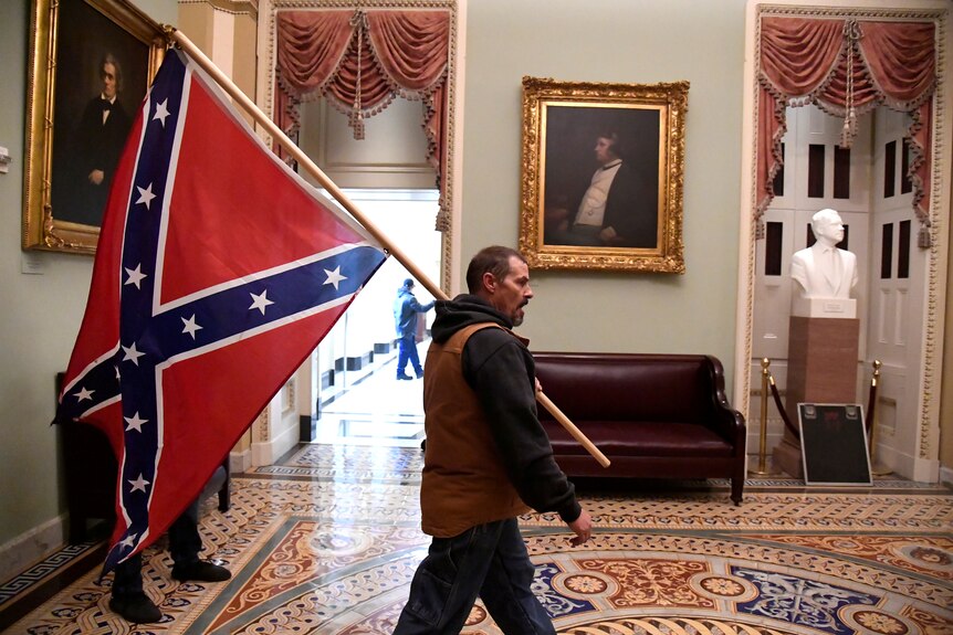 A man carriers a Confederate battle flag in the US Capitol.