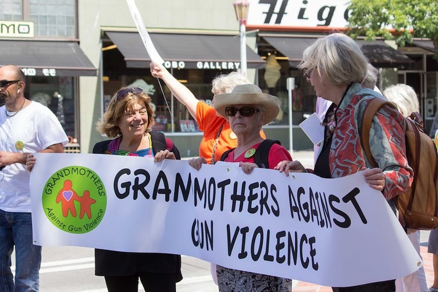 Older women carry a banner that reads Grandmothers Against Gun Violence