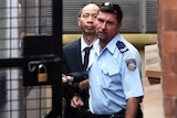 Robert Xie being escorted to a prison vehicle at the NSW Supreme Court after being granted bail.