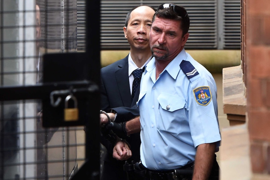 Robert Xie being escorted to a prison vehicle at the NSW Supreme Court after being granted bail.