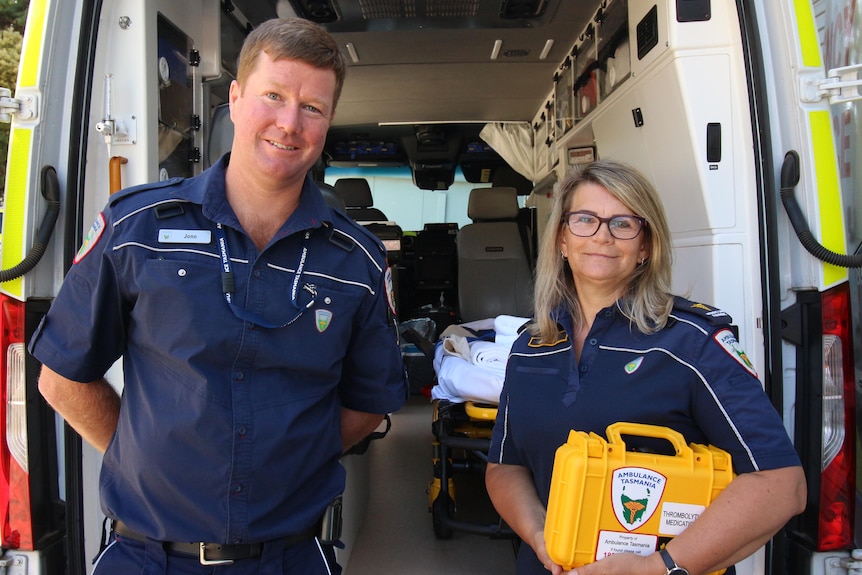 Paramedics Jono Head and Tammy Lee pose behind an ambulance.