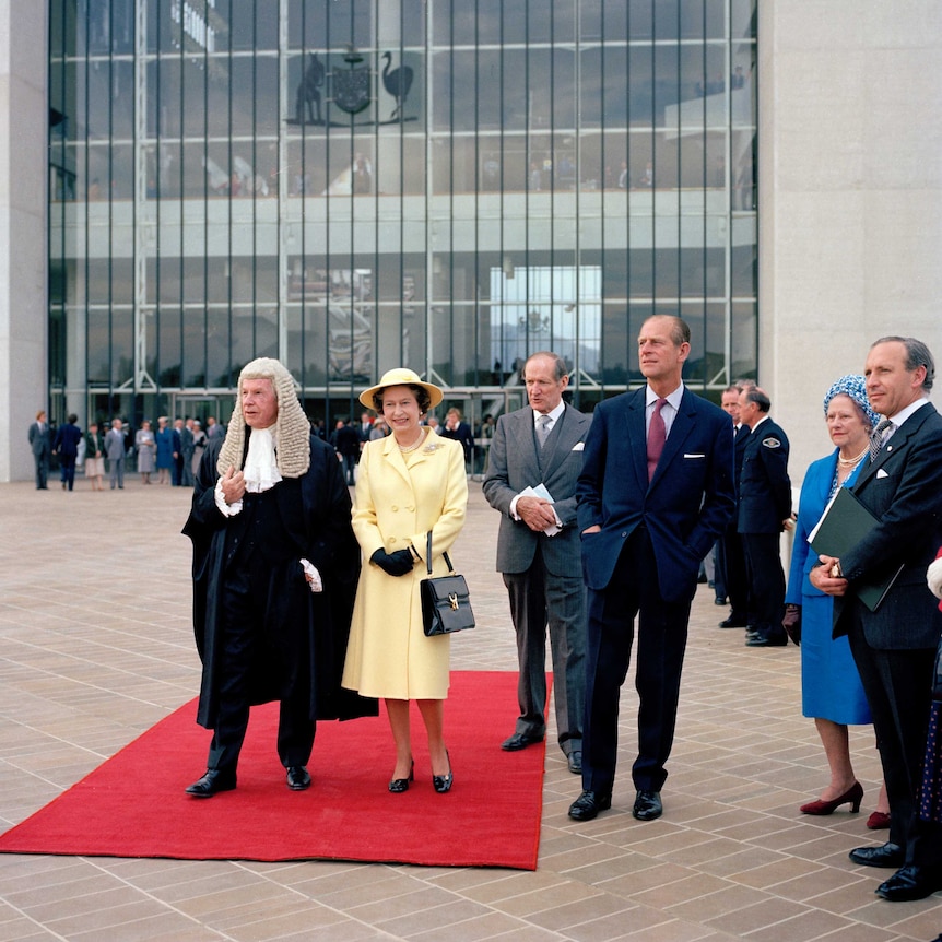 Queen Elizabeth, a judge and other officials in front of the High Court.