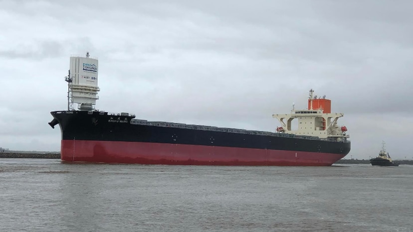 A wide shot of a large bulk carrier on the water