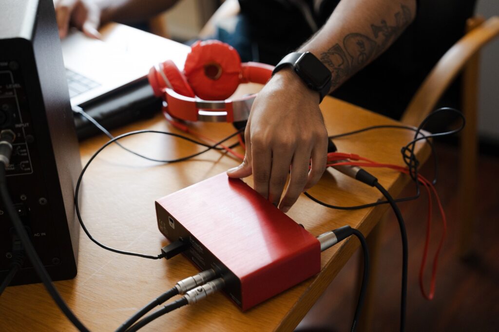 Um adolescente conectando cabos conectados a uma peça de tecnologia.