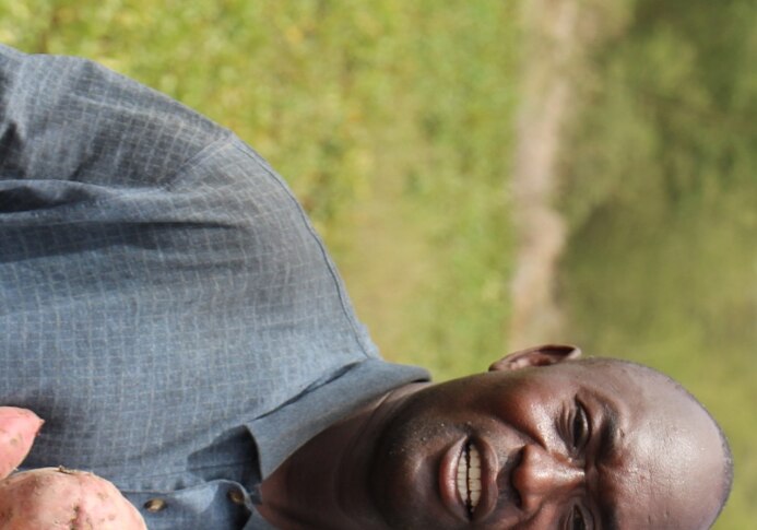 A man standing with sweet potatoes