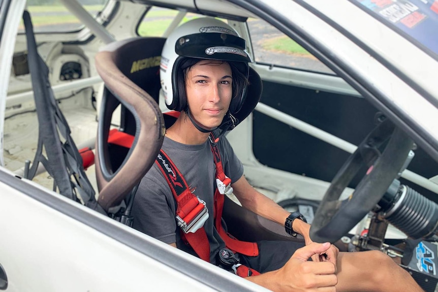 Braedyn Cidoni sits in a race car wearing a crash helmet and racing harness at the Norwell Motorplex on the northern Gold Coast.