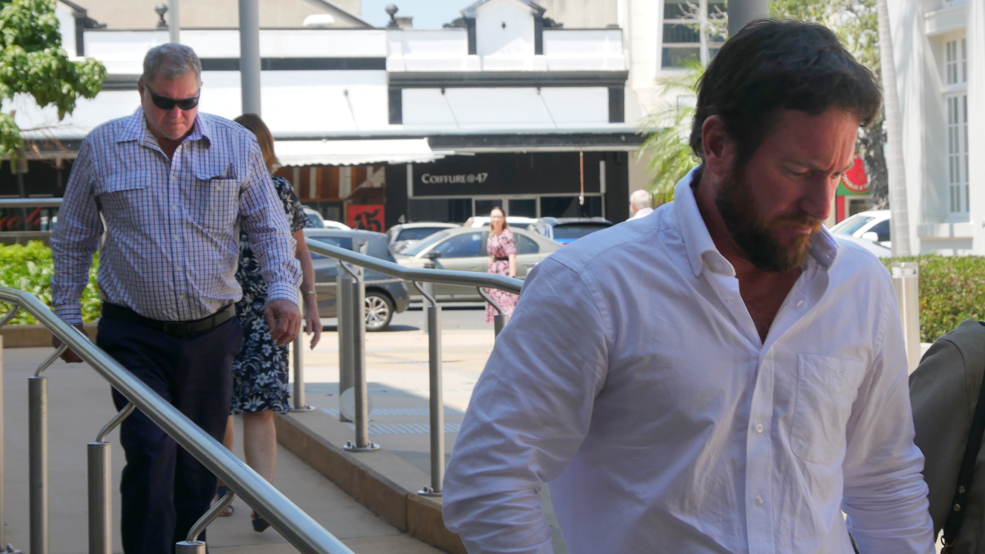 Two men in business wear walking in to court