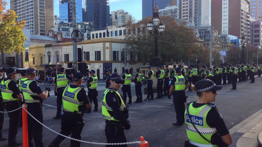 Police stand ready for protesters on Bourke Street outside Victoria's State Parliament