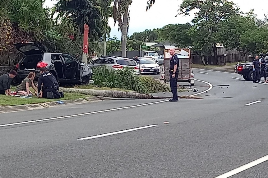 Emergency services at the scene of a car crash on a suburban street.