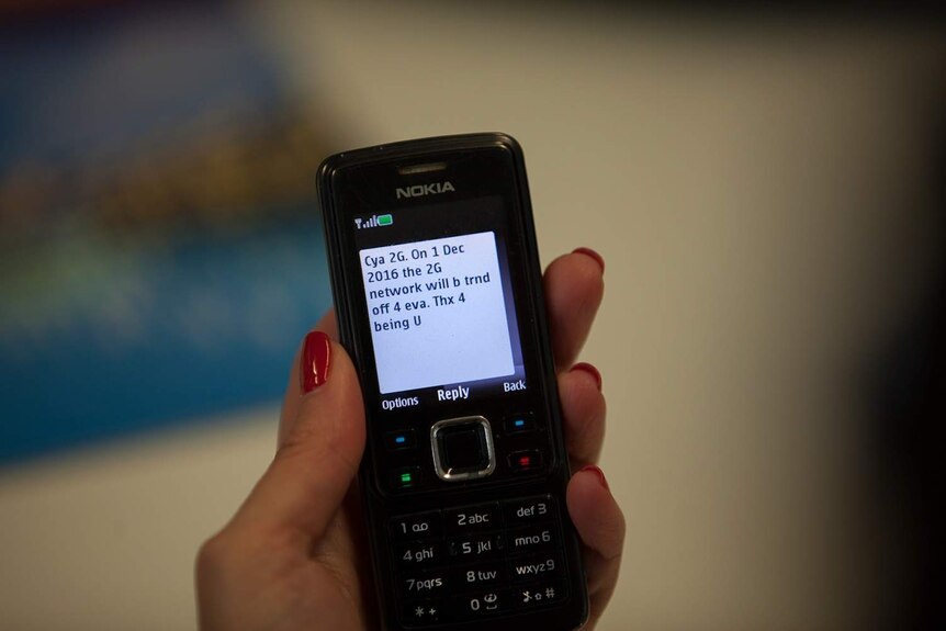A hand holding a mobile phone with a message on the screen.