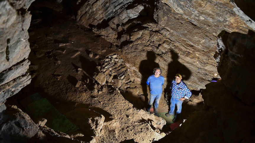 Two men standing in a limestone cave