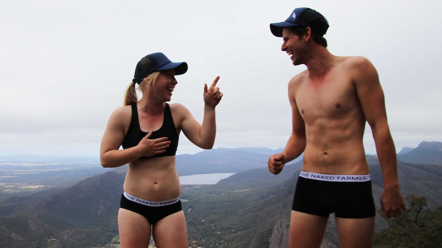 A female and male modelling underwear on a large hill