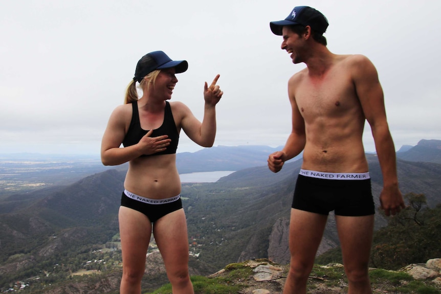 A female and male modelling underwear on a large hill