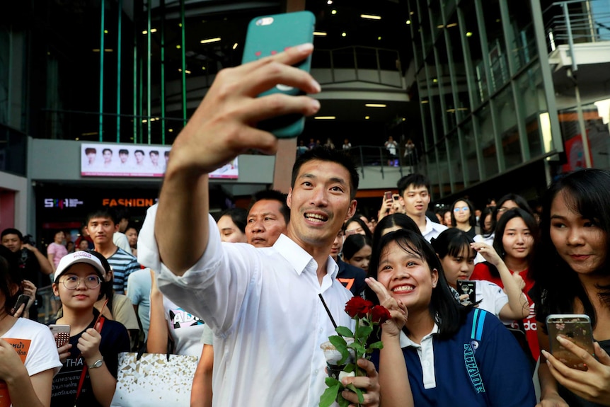 A man taking a selfie with a crowd of people