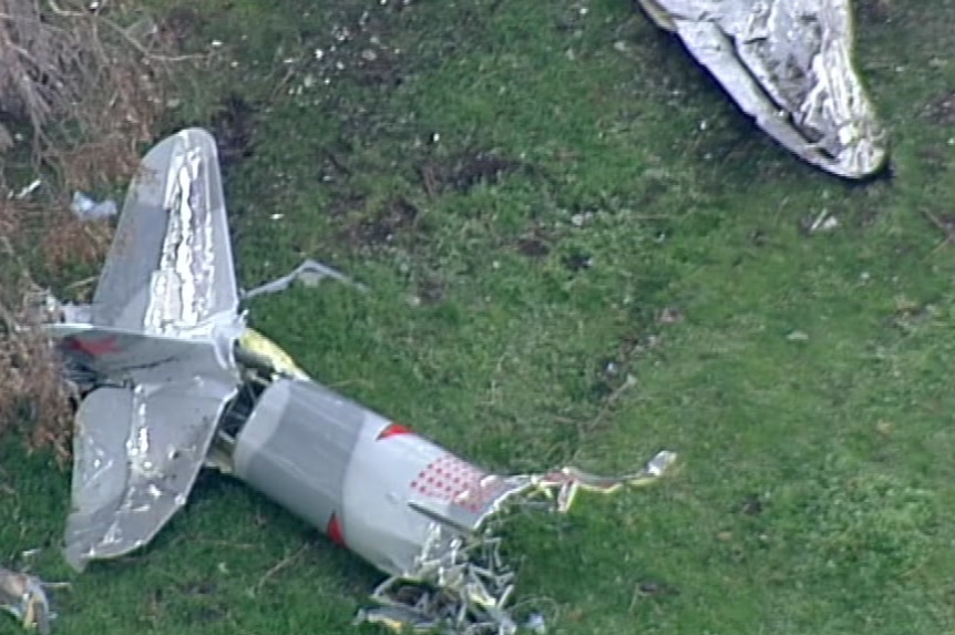 Plane crash wreckage in a paddock.