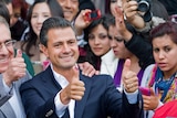 Enrique Peña Nieto gives his thumbs up, showing ink-stained thumbs, after casting his vote.