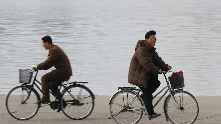 Men ride bikes in Pyongyang