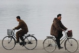 Men ride bikes in Pyongyang