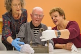 Queensland Museum curator Tracy Ryan, Ben Blunderfield and daughter Rosslyn look at the inkwell.