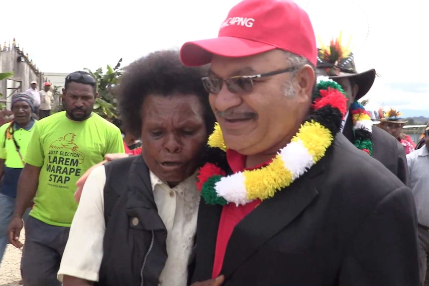 Peter O'Neill with his hand around a lady while campaigning.