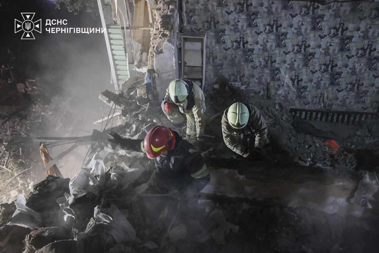 fire fighters dig through rubble in an apartment building