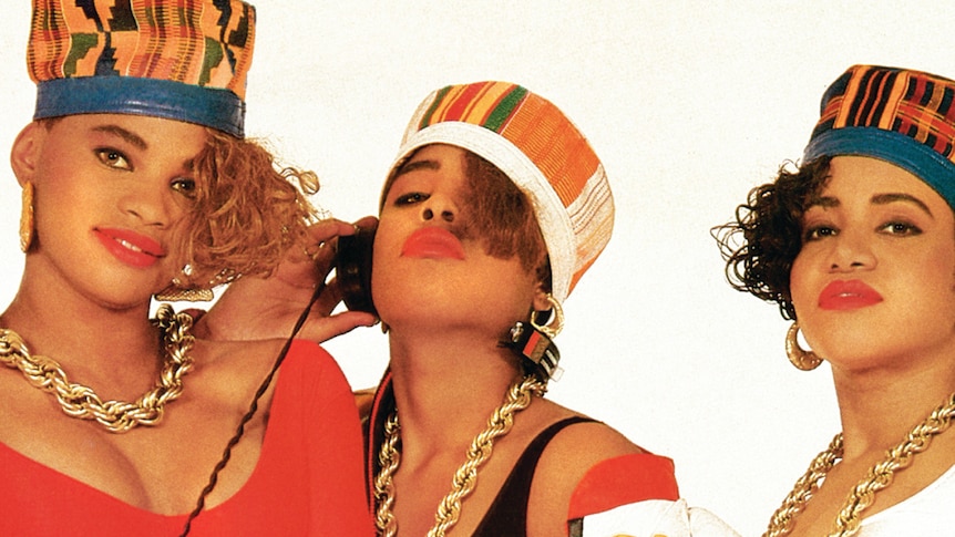 Three women of Salt-N-Pepa wear hats and thick necklaces