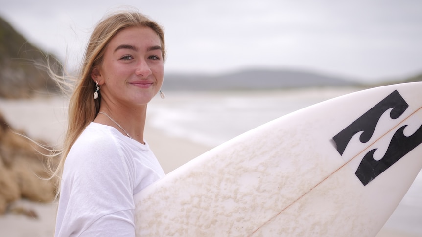 A teenage girl with a surfboard