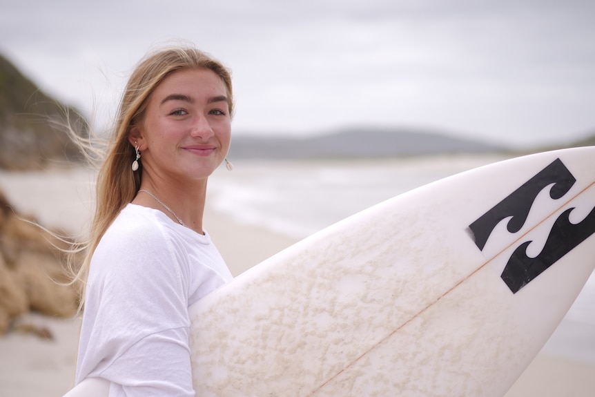 A teenage girl with a surfboard