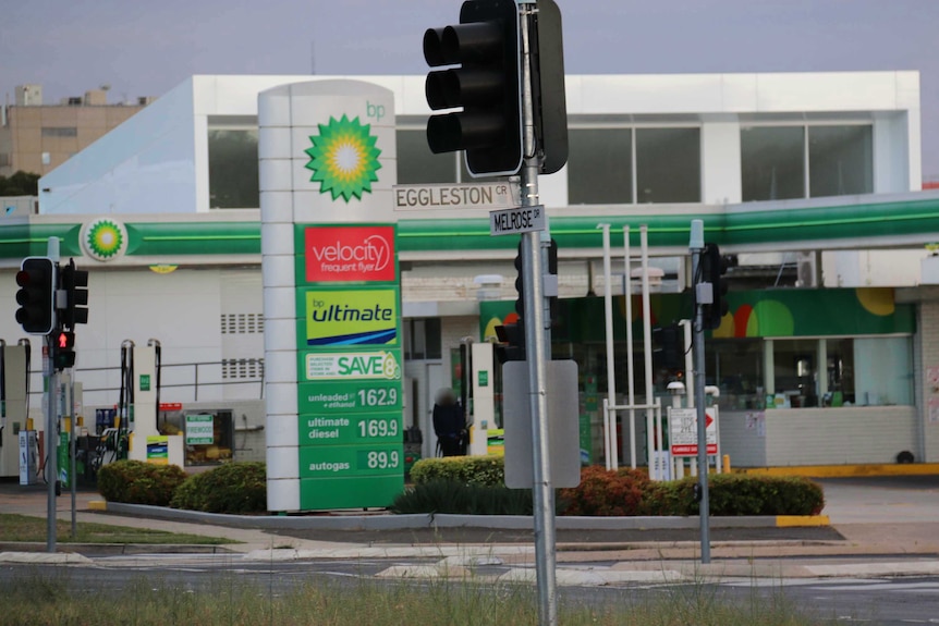 A man stands at a BP petrol station during a police siege.
