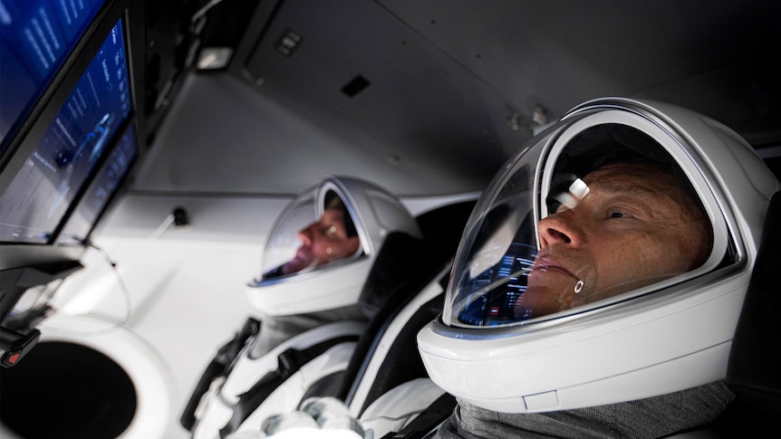 Two men in cockpit of spacecraft