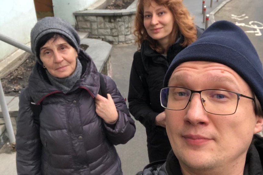 Three people walking on a footpath in Kyiv.