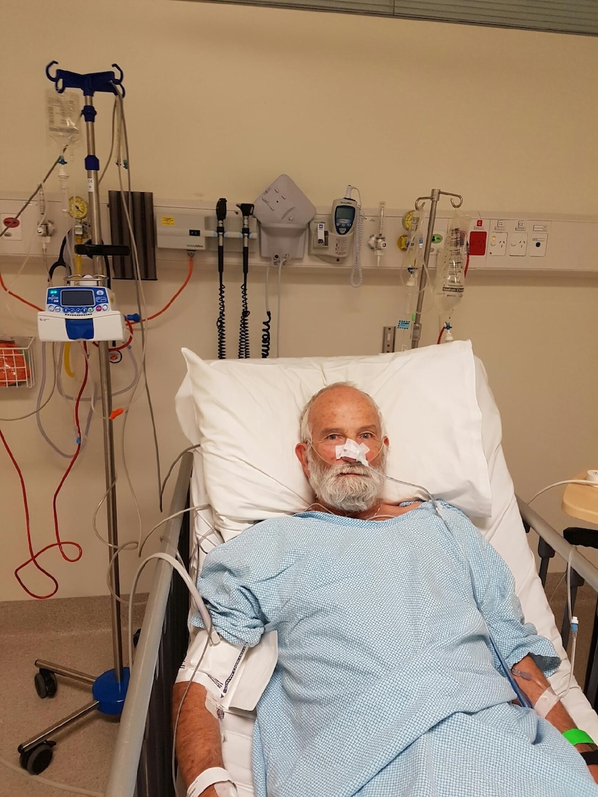 A man in a hospital bed with a tube going into his nose.