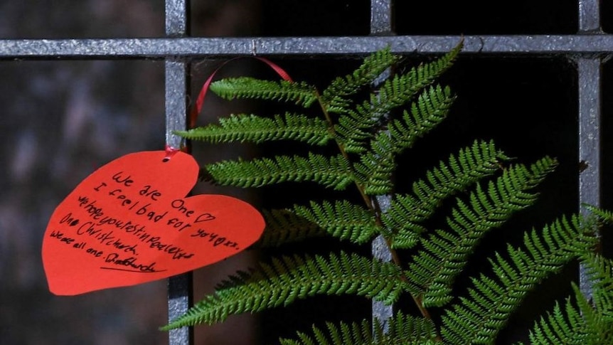 A silver fern next to a love heart at a makeshift memorial