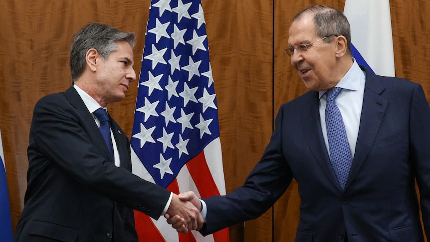 Anthony Blinken shakes hands with Sergei Lavrov.