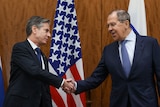 Anthony Blinken shakes hands with Sergei Lavrov.