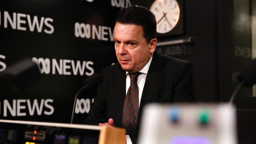 Concerned looking Nick Xenophon sitting in ABC Radio studio