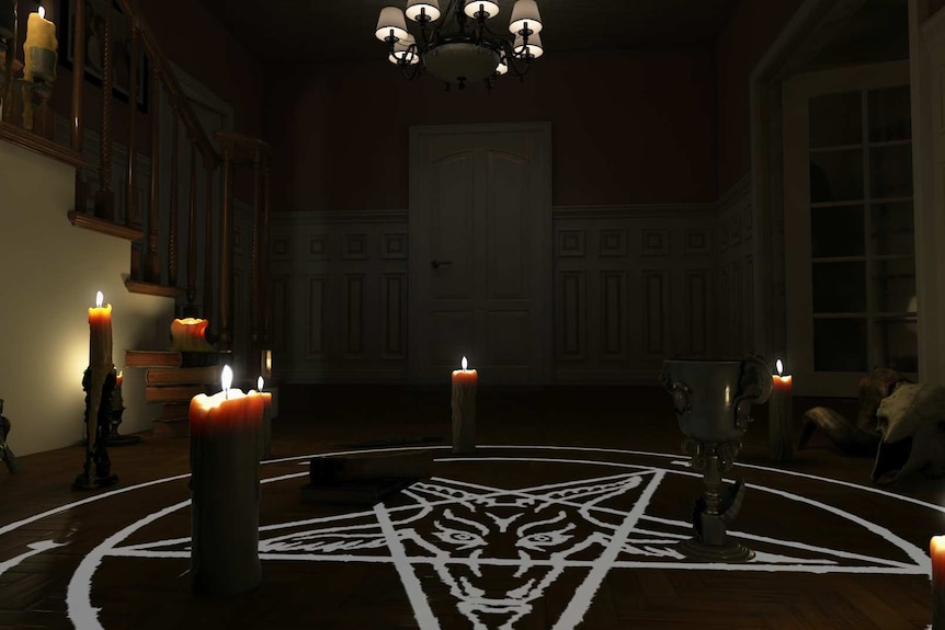 Indoor shot, darkened room with pentagram on floor with goat head painted in centre, candles around it, and pendant light above.