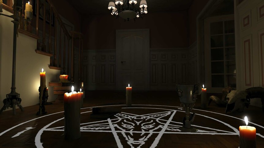 Indoor shot, darkened room with pentagram on floor with goat head painted in centre, candles around it, and pendant light above.