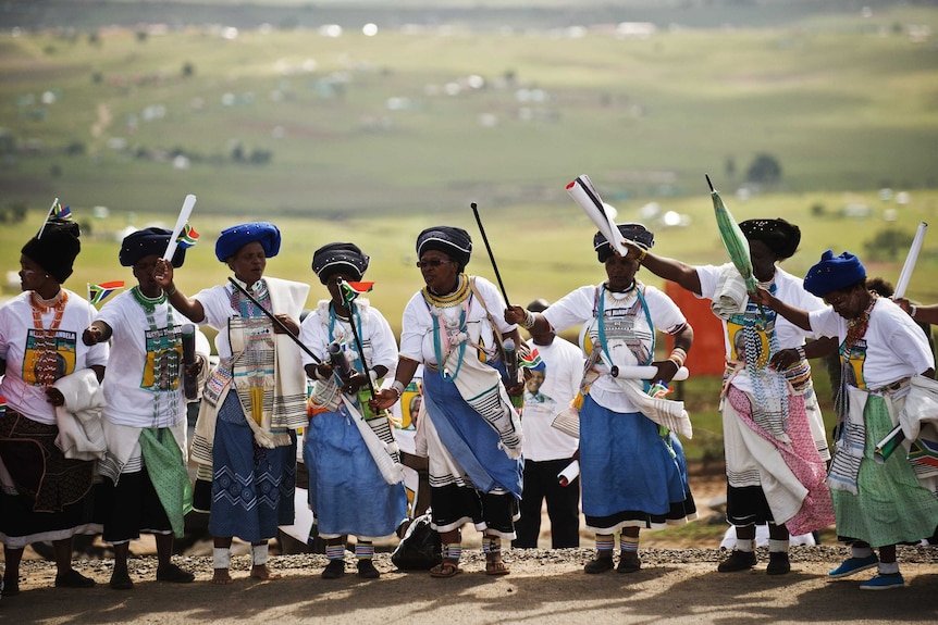 Xhosa women in traditional dresses sing and dance in Qunu