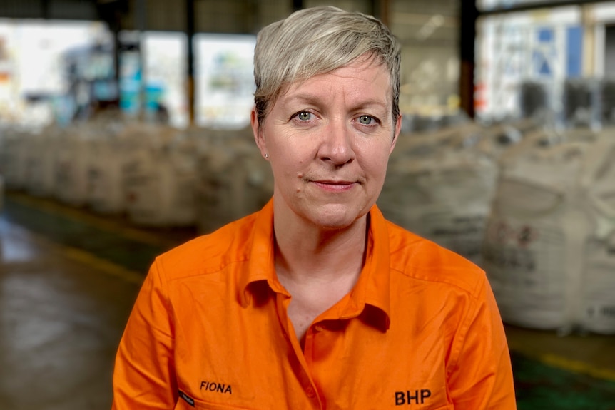 A woman wearing an orange shirt.