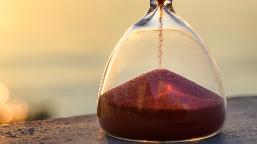 a close up of an hourglass with sand falling through the middle