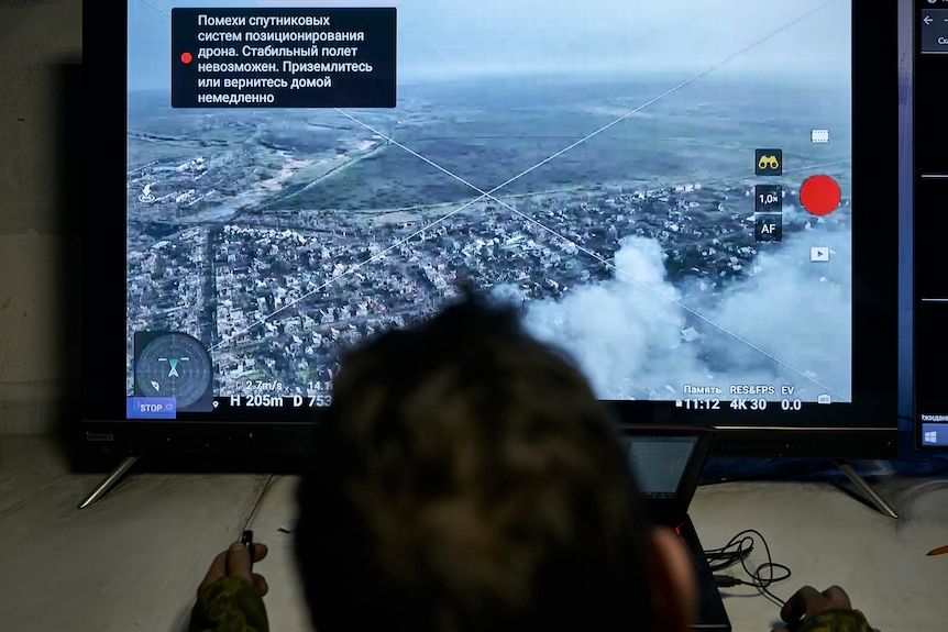 A Ukrainian soldier watches a drone feed from an underground command centre.