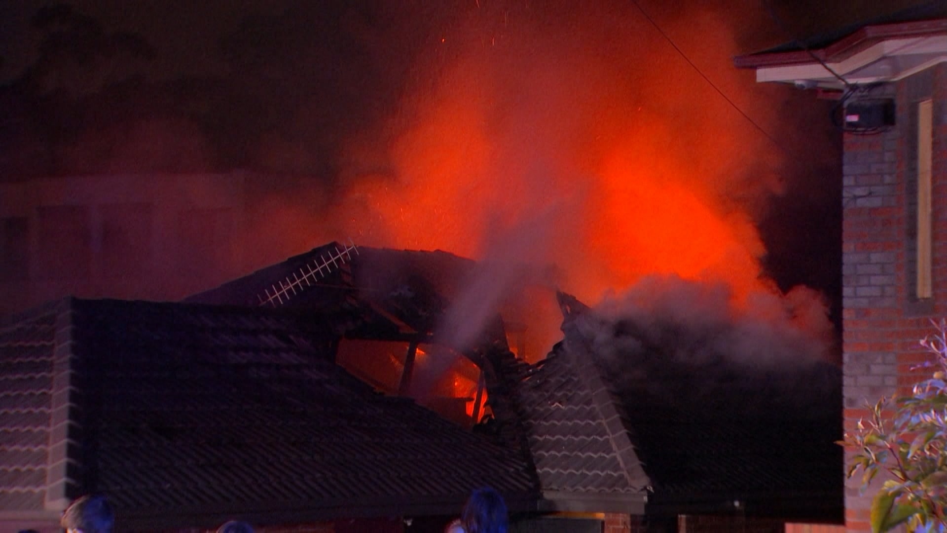 A burning house at night showing flames lighting up the darkness